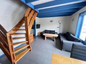 a living room with a staircase and a couch at Nautnes Costal Heaven in Nautnes
