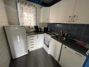 a kitchen with a white refrigerator and a sink at Nautnes Costal Heaven in Nautnes