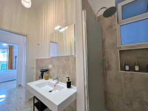 a bathroom with a white sink and a shower at Palermo central stay in Palermo +289 photos