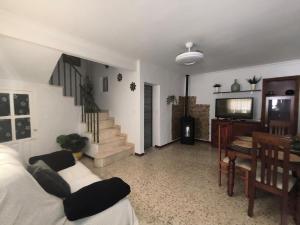 a living room with a couch and a tv and stairs at Casa la parra in Ardales