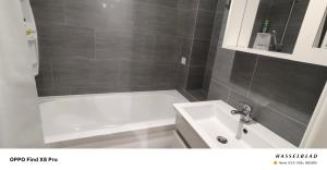 a bathroom with a white tub and a sink at Buiucani Apartament Chișinău in Chişinău