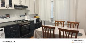 a kitchen with a stove and a table with chairs at Buiucani Apartament Chișinău in Chişinău