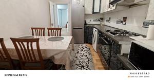 a kitchen with a table and a kitchen with a stove at Buiucani Apartament Chișinău in Chişinău