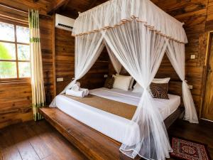 a bedroom with a canopy bed in a log cabin at wood cabin sigiriya in Sigiriya