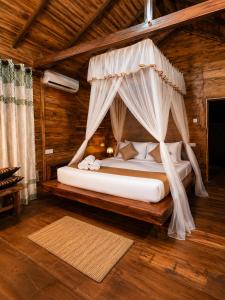 a bedroom with a bed with a mosquito net at wood cabin sigiriya in Sigiriya