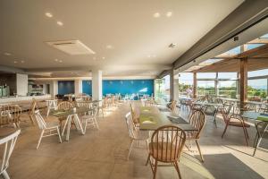 a restaurant with tables and chairs and windows at Harmony Crest Resort in Kos
