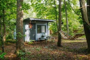 a hammock in front of a tiny house in the woods at Värska kämping in Värska