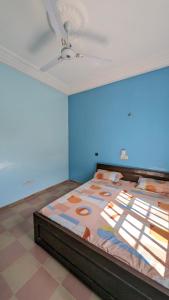 a large bed in a room with a blue wall at Hôtel St Jo in Bohicon