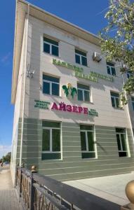 a building with a sign on the side of it at Sapar de lux hotel in Qyzylorda
