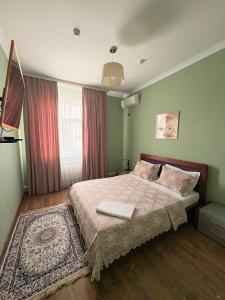 a bedroom with a large bed and a rug at Sapar de lux hotel in Qyzylorda
