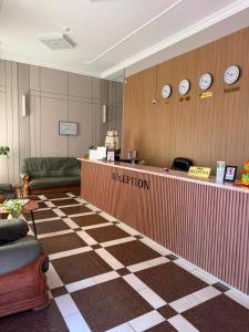 a hotel lobby with a reception counter and clocks on the wall at Sapar de lux hotel in Qyzylorda