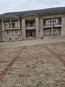 a large building with a dirt ground in front of it at GRACECUT HOTEl in Enugu