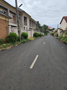 an empty street in a residential neighborhood with buildings at GRACECUT HOTEl in Enugu