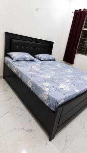 a bed with a blue comforter and pillows on it at Hotel Panchmukhi Ashram Ayodhya Dham in Ayodhya