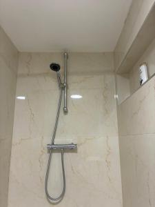 a shower with a shower head in a bathroom at Edenderry Central Rooms in Edenderry +17 photos