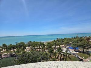 a view of a beach with palm trees and the ocean at Lindo Duplex na orla de Pajuçara in Maceió