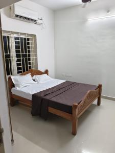 a bed in a white room with a bed sidx sidx sidx at Kmr villa in Madurai