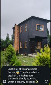 a black house with the wordsjust look at this integrated against the irish green at Rimaaia homestay in Lāitlyngkot