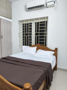 a bedroom with a large bed with a window at Kmr villa in Madurai