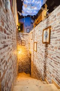 an alley way with brick walls and pictures on the wall at Le grenier des sorciers in Balbigny