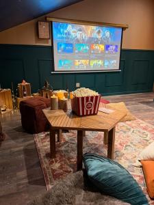 a table with a box of popcorn and a screen at Le grenier des sorciers in Balbigny