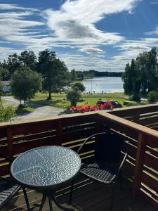 a table and chairs on a deck with a view of a lake at Toten Hotel Sillongen in Eklund +6 photos