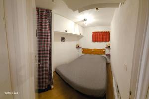 a small bedroom with a bed in a small room at Appartement T2 Chalets Superd in Le Dévoluy