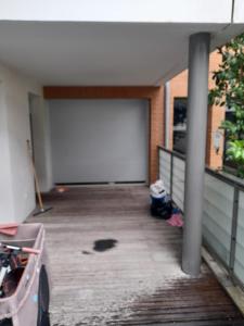 an empty garage with a large white garage door at Appartement in Tournefeuille
