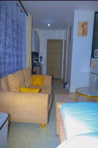 a living room with a couch and a bed at Eden Homes in Nairobi