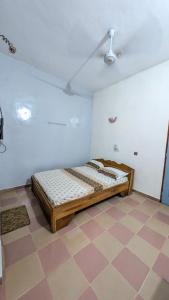 a bed in a room with a checkered floor at Hôtel St Jo in Bohicon