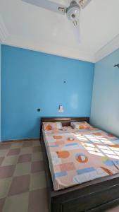 a bed in a room with a blue wall at Hôtel St Jo in Bohicon