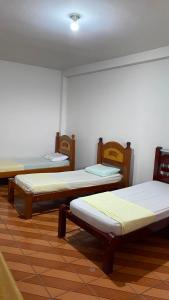 a room with three beds in a room at Hotel Gênio in Pouso Alegre