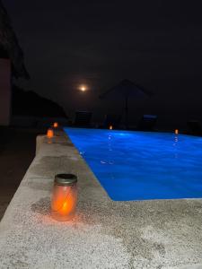 a candle sitting on the edge of a swimming pool at night at Hostal Punta El Zonte in El Zonte