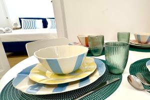a table with a bowl and plates and glasses at Villa Lucia in Torre del Greco