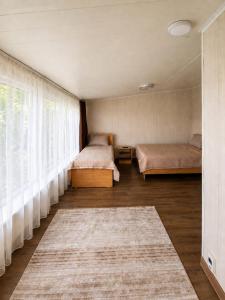 a bedroom with two beds and a large window at Valentina`s Guesthouse in Korumdy