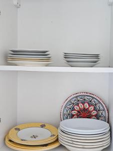 two stacks of plates and bowls on a shelf at Rakkez's house in Hiboun