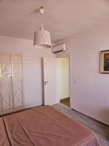 a white room with a bed and a ceiling at Rakkez's house in Hiboun +10 photos