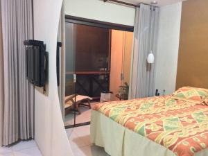 een slaapkamer met een bed en een tv in een kamer bij Monte Castelo Gravatá - Flat in Gravatá