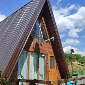 a small wooden house with a large window on it at Vikendica Hećo in Višegrad