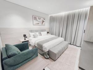 a bedroom with a bed and a couch and a chair at شقق الإيجار - العروبه in Riyadh