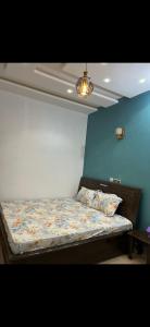 a bed in a room with a blue wall at Empereur City in Ouidah +11 photos