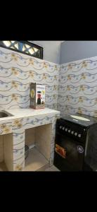 a kitchen with a counter and a sink and a stove at Empereur City in Ouidah