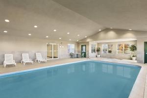 ein großer Pool in einem Haus mit Stühlen in der Unterkunft Country Inn & Suites by Radisson, Frackville (Pottsville), PA in Mount Pleasant