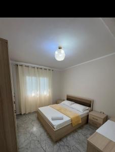 a bedroom with a bed and a light on the ceiling at Hotel Dalian in Baks-Rrjoll
