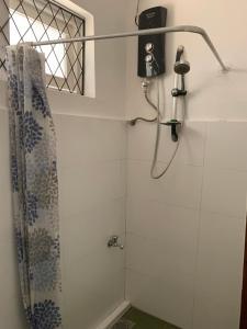 a shower in a bathroom with a shower curtain at Emerald canopy retreat in Kandy +29 photos