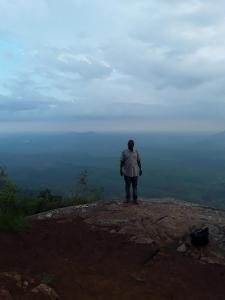 a man standing on the top of a mountain at Sheiza in Kampala