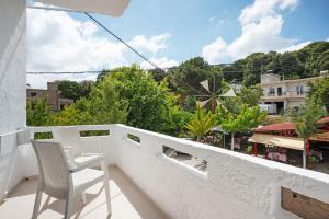a white chair sitting on a balcony with a view at Dionysus House Lasithi Plateau in Magoulás