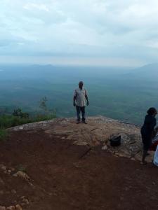 a man standing on the top of a mountain at Sheiza in Kampala