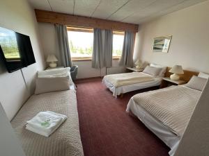 a hotel room with two beds and a television at Toten Hotel Sillongen in Eklund