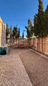 a patio with benches next to a stone wall at Sidi kaouki Private House in Sidi Kaouki